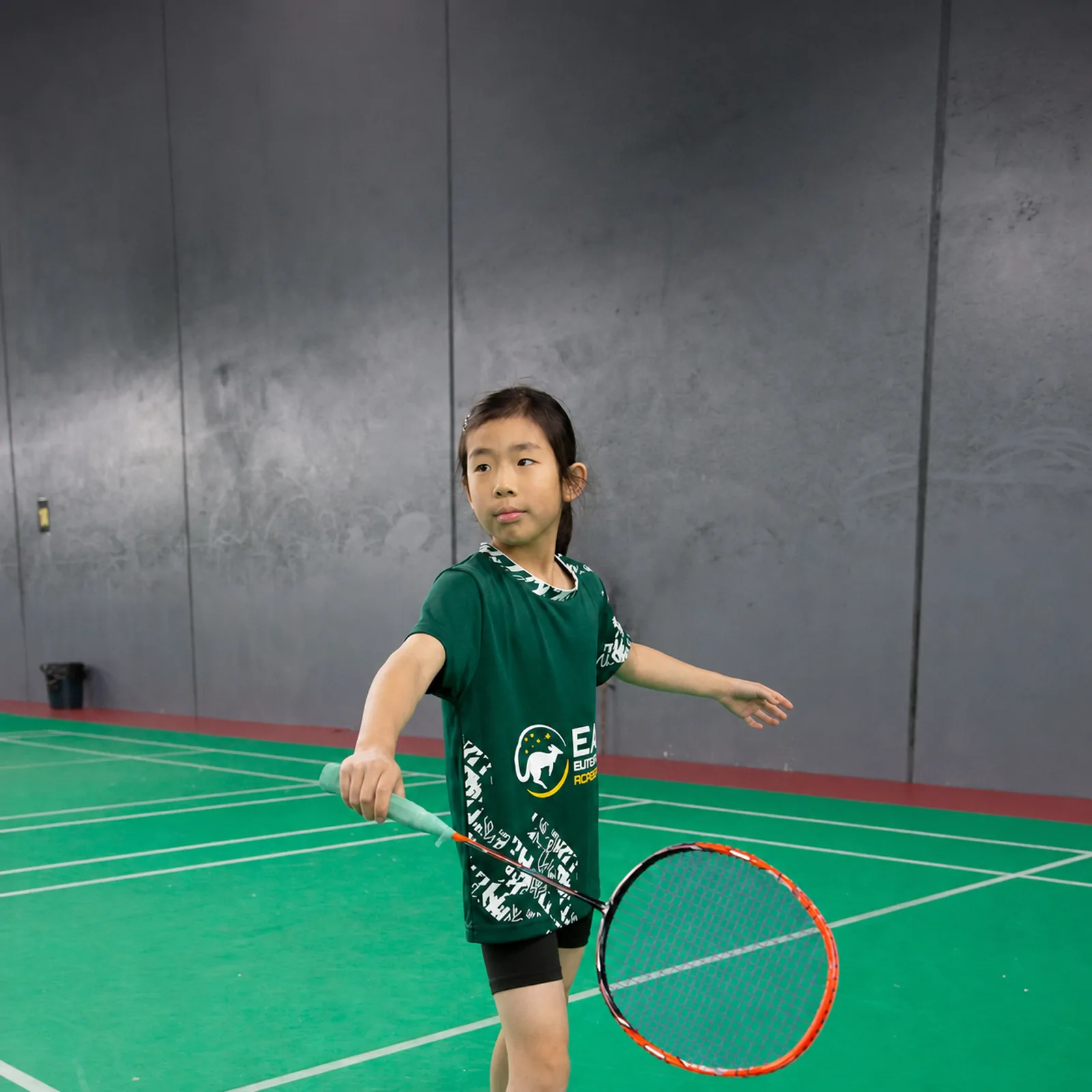 A young player mid-swing on court