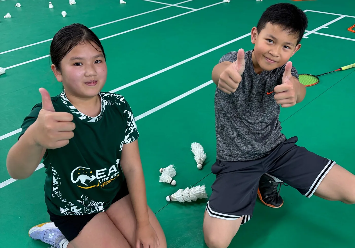 Two EAA juniors giving a thumbs up on court