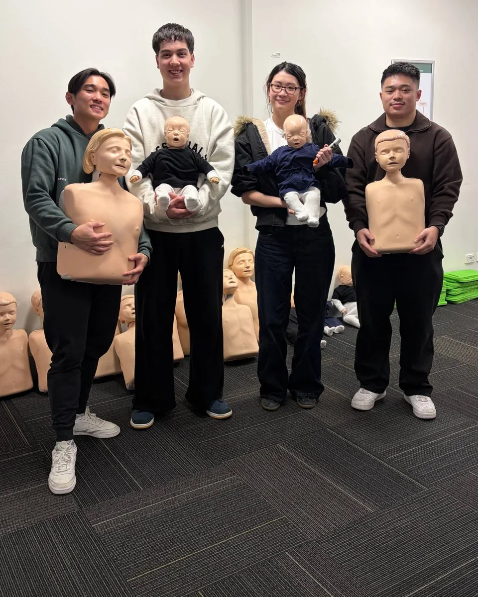 EAA coaches at their first aid training, holding infant and child CPR mannequins